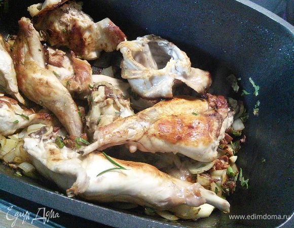 Части кролика обжарить в разогретом масле со всех сторон до золотистого цвета(я обжариваю прямо в посуде, в которой потом запекаю) . Выложить на тарелку. Лук, чеснок и бекон порезать мелко, сначала выложить бекон, обжарить, добавить лук, чеснок и довести до золотистого цвета. Затем добавить грибы(у меня из прошлогодней заморозки) и  мелко порубленную зелень розмарина и шалфея. Выложить мясо с образовавшимся мясным соком и прогреть все вместе. 