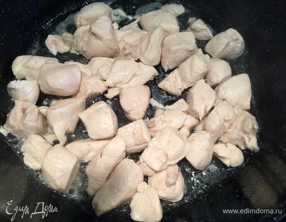 В сковороду налить подсолнечное масло, положить кусочки курицы, готовить на среднем огне, периодически помешивая.