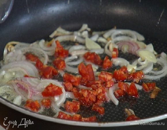 Колбаски почистить, нарезать небольшими кусочками и добавить в сковороду с луком с чесноком.