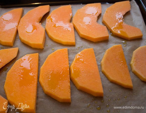 Тыкву очистить от кожицы и семян, нарезать тонкими ломтиками, сбрызнуть оливковым маслом и запечь в течение 15 минут в духовке.