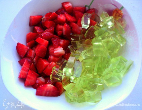 Остальную клубнику порезать на кусочки. Так же кубиками порезать застывшее желе.