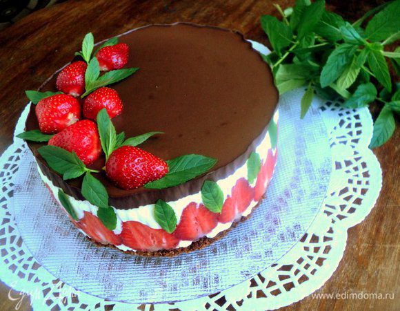 Снять с торта разъемное кольцо и бумагу для выпечки. Украсить торт клубникой и листиками свежей мяты.
