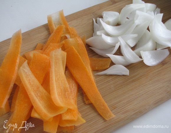 Морковь настругать тонкими лентами с помощью овощечистки. Репчатый лук нарезать лепестками - по-восточному.