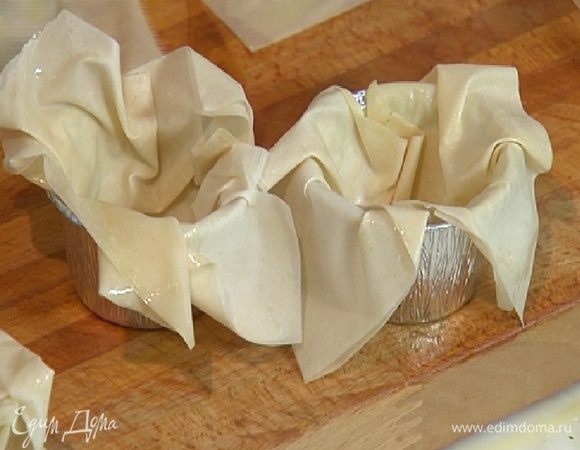 Разрезать листы на 6 квадратов и уложить каждый квадрат в небольшую форму для выпечки смазанной стороной вниз, так чтобы края теста свешивались.