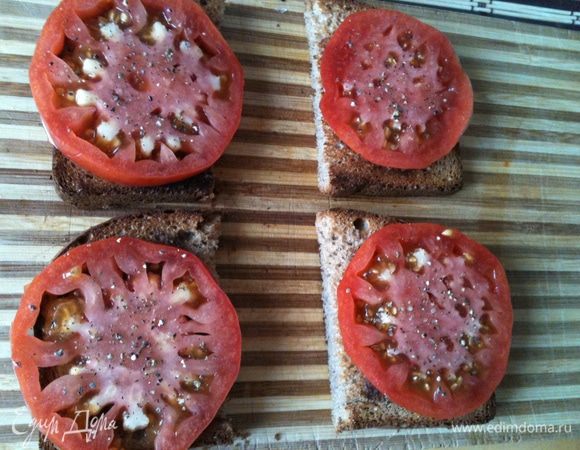 Положить на хлебушек дольки томатов.