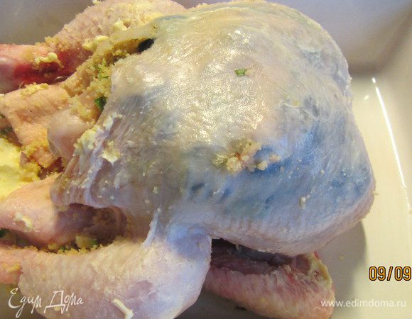 У курицы со стороны грудки делаем карман (аккуратно отделяем кожу, стараясь ее не повредить). Выкладываем туда нашу начинку, распределяем ее под кожей. Слишком туго карман набивать на стоит, иначе он может порваться при запекании. Закрепляем зубочисткой. Курицу солим и перчим и натираем сливочным маслом (оно должно быть комнатной температуры). Грудку накрываем смазанной маслом фольгой. Отправляем курочку в духовку 190 гр примерно на 1 час 20-30 минут. Периодически поливаем ее выделившимся соком. Минут за 30 до готовности снимаем фольгу, чтобы грудка приобрела загорелую корочку. 
