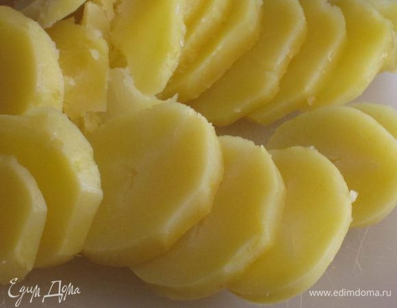 Картофель отварить в мундире до готовности,почистить и нарезать тонкими кружочками.