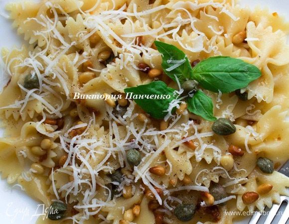 Снять орехи с чесноком с огня, добавить в  отваренную пасту, перемешать. добавить каперсы,  приправить черным перцем, посыпать тертым сыром и подавать в теплом виде. 