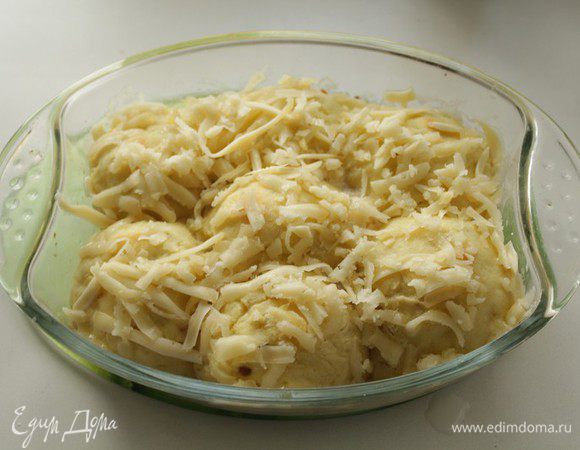 За 10 минут до окончания запекания достать форму, смазать шарики  молоком, посыпать тертым сыром и отправить опять в духовку