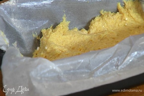 Бумагу для выпечки смазать сливочным маслом, выстелить небольшую продолговатую форму и равномерно распределить тесто.