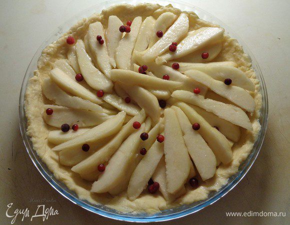 Выложить всю внутреннюю часть тарта по спирали дольками груш. Добавить для украшения немного ягод брусники.