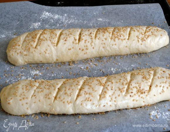 Смазать этой смесью заготовки багетов и присыпать кунжутным семенем (по желанию). Дать багетам постоять еще минут 20-30. За это время включить разогреваться духовку на 180 С. Выпекать 25 минут. Готовые багеты остудить на решетке.