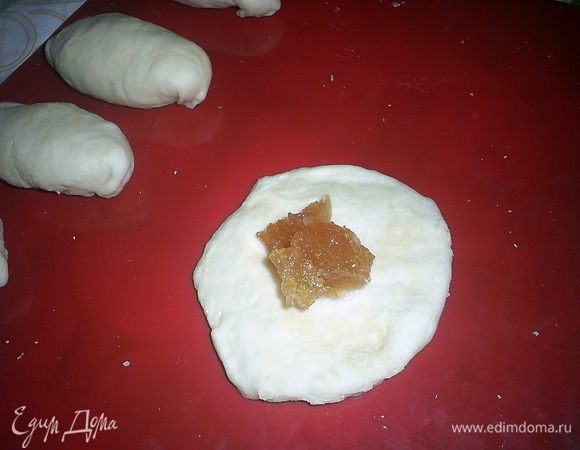 Отделяем небольшую часть теста, раскатываем колбаской и нарезаем на небольшие кусочки. Их размер зависит от желаемого размера будущих пирожков.
Каждый кусочек я просто руками расплющиваю в лепешку, кладу начинку, формирую пирожок и кладу на противень с пергаментом, швом вниз.
Мне понадобился примерно стакан повидла, но точное количество зависит от густоты повидла, чем оно жиже, тем меньше его кладите, и от ваших вкусов и предпочтений.