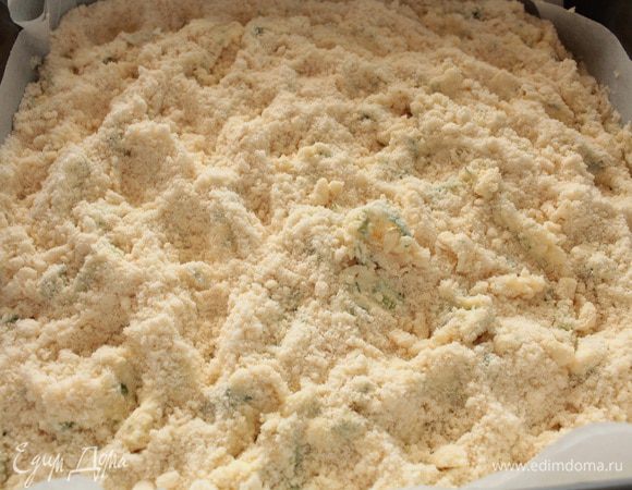 Сверху меньшую часть мучной крошки.Обычно у такого типа выпечки после выпекания иногда остается сухая мучная пыль.Я поступаю так:вилочкой слегка вмешиваю крошку в творожную смесь,вот так.