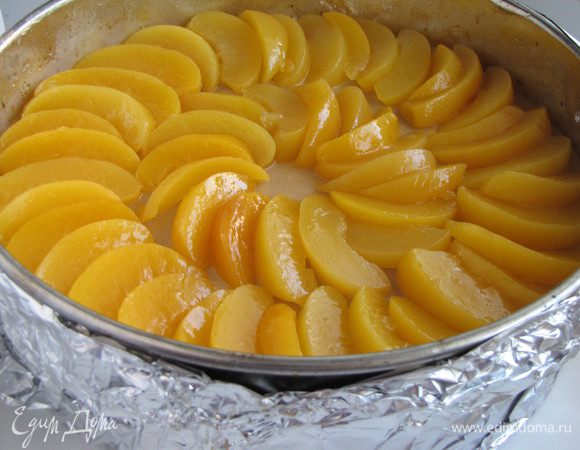 На следующий выложить на торт нарезанные персики.