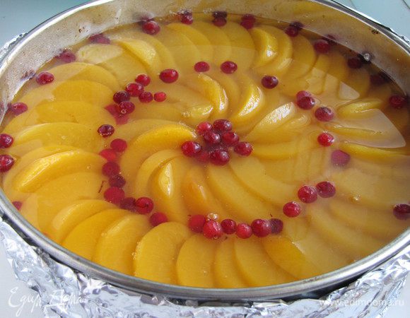 Добавить ягоды брусники по желанию. Желе развести соком от персиков и приготовить его, согласно инструкции на упаковке. Залить торт полученным желе.