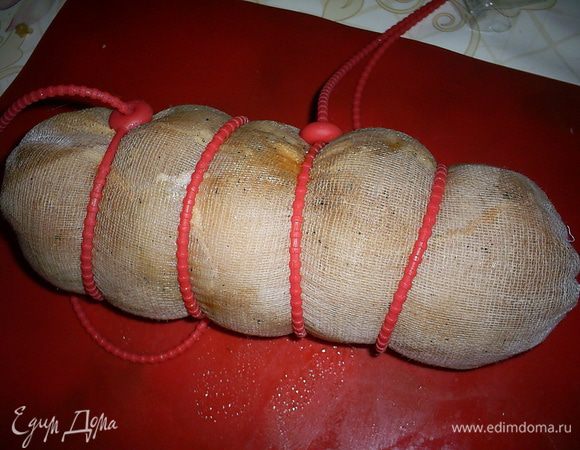 По истечению нужного времени достаем грудку, обсушиваем бумажными полотенцами. Натираем грудки пропущенным через пресс чесноком.
Берем марлю, сворачиваем ее в три слоя, затем с ее помощью сворачиваем грудки "колбаской" как можно туже. Несколько раз перевязываем бечевкой или воспользуемся специальными силиконовыми шнурочками.