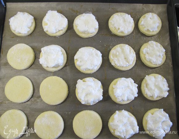 Стол припылить мукой. Раскатать тесто толщиной 5 мм, чашкой вырезать кружки и выложить их на противень. Коржики смазать взбитым белком, посыпать сахаром.