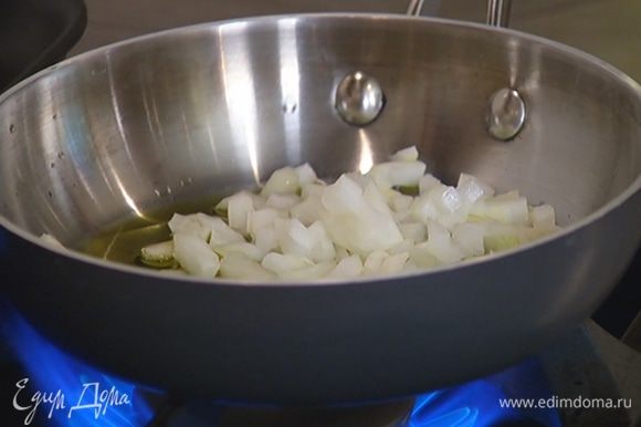 Разогреть в отдельной сковороде оставшееся оливковое масло, выложить лук, посолить его и обжарить.