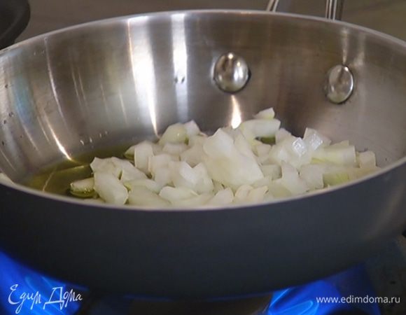 Разогреть в отдельной сковороде оставшееся оливковое масло, выложить лук, посолить его и обжарить.