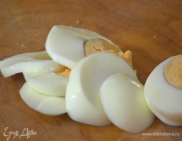 Яйца отварить, почистить и нарезать вдоль пластинками.