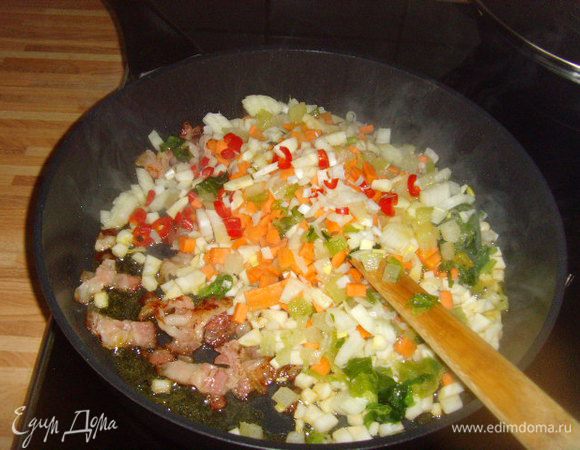 Прожарить бекон, добавить овощи. Пассеровать овощи до полуготовности. 