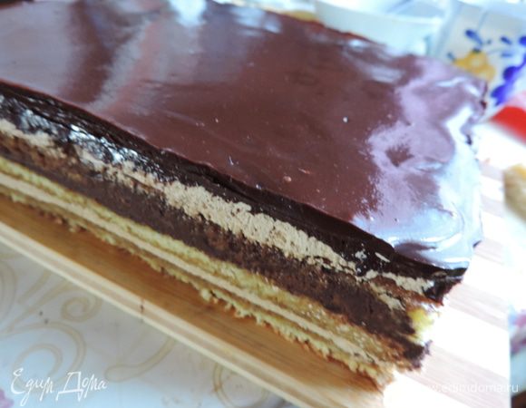 На поверхность торта ее желательно процедить через мелкое ситечко и ничем не трогать. Она должна растечься сама и сгладить все неровности. Снова убираем торт в холодильник. На этот раз до утра. Утром освобождаем торт от рамки. Если собирали без нее, значит острым ножом надо аккуратно обрезать бока торта. Нож надо предварительно нагреть в горячей воде и вытереть салфеткой! И так перед каждым срезом, чтоб они были аккуратными.