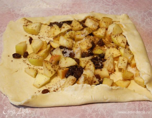Яблоки режем, удаляем косточки.
Каждый кусок теста раскатываем. Сильно тонко не нужно, а то яблоки порвут тесто.
Выкладываем начинку: у меня яблоки, изюм и немного сахара с корицей. Сворачиваем рулет. Бока рулета прижмите, чтобы не раскрутился в процессе выпечки.
