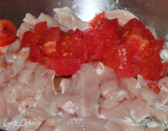 Добавляем грудку и помидор в сковороду. Перемешиваем и тушим 5 минут.