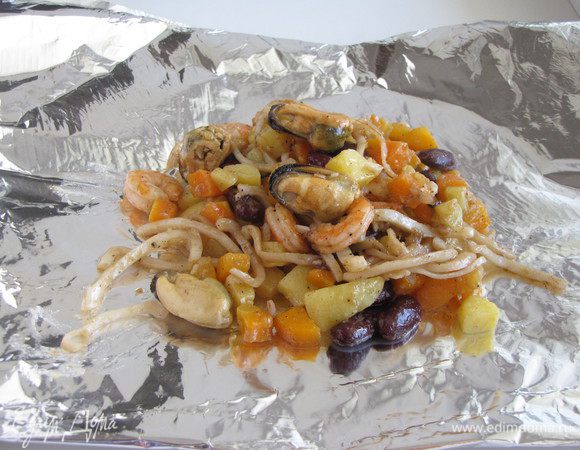 Фольгу сложить в два слоя, придав форму квадрата. Выложить морепродукты с овощами.