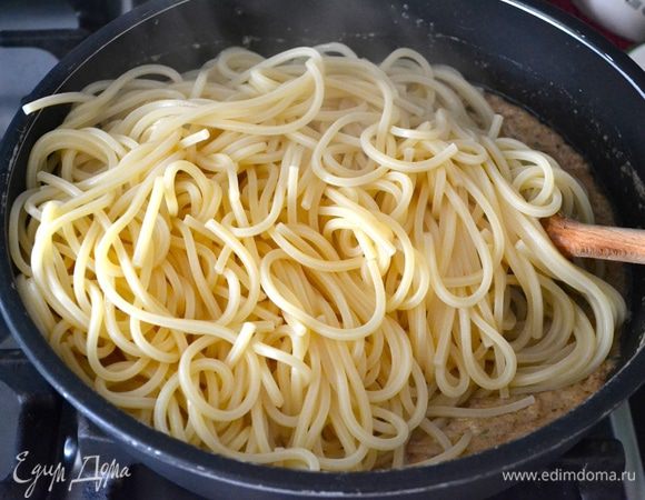 Тем временем готовую пасту скинуть на дуршлаг (рекомендую заранее отложить чашку жидкости от варки спагетти... Вам может понадобиться, если соус получится слишком густым, или просто, чтобы добиться желаемой консистенции готового блюда). Выложить в сковороду с соусом и все как следует перемешать (добавить чуть-чуть оставленной жидкости, если есть желание).