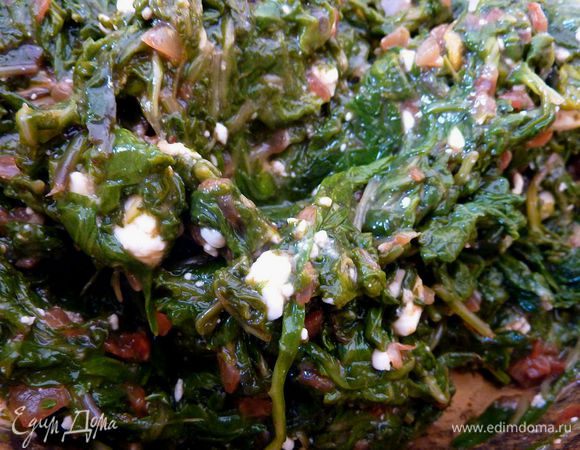 Лук порезать очень мелко. Чеснок выдавить через пресс. Разогреть оливковое масло на сковороде, обжарить лук, чеснок и паприку, жарить, помешивая, минут 5. 
Шпинат который остыл, отжать очень хорошо и порезать. В большой миске перемешать шпинат и обжаренный лук, раскрошить туда половину феты и соль. Яйца слегка взбить и ввести в шпинатную смесь. Перемешать всё до однородности. 