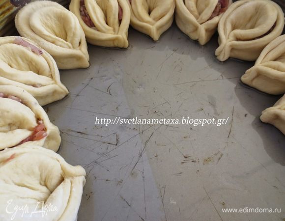 Заготовки выложить в круглую форму по кругу рядами, предварительно смазав ее растительным маслом( если форма не пригораемая)  или  же застелить дно формы бумагой для выпечки и затем выложить заготовки