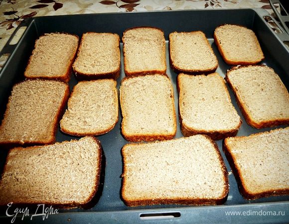 Нарезаем хлеб пластами и раскладываем на противень.