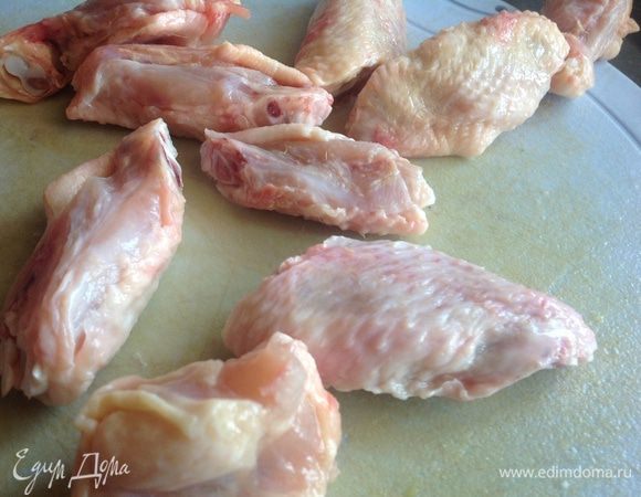 Духовку разогрейте до 200 градусов.

Куриные крылышки разрежьте по суставу.