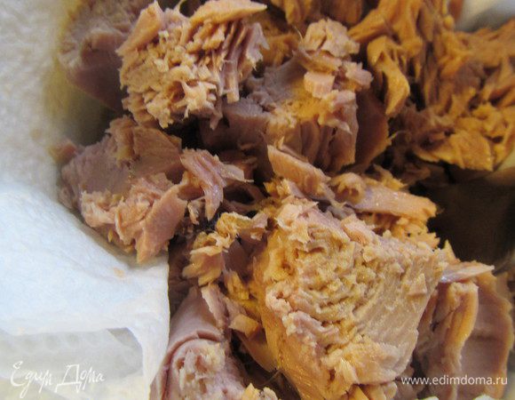 С тунца сливаем жидкость и разминаем его вилкой.