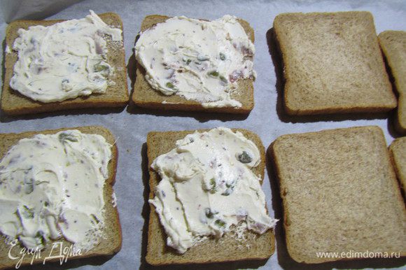 Собираем наши сэндвичи. На противень выкладываем половину кусочков хлеба. Намазываем их соусом. Можно его сразу с тунцом перемешать, чтобы последний не рассыпался.