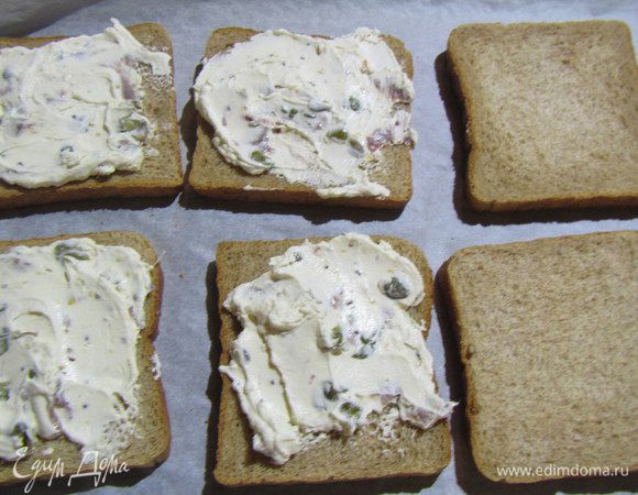 Собираем наши сэндвичи. На противень выкладываем половину кусочков хлеба. Намазываем их соусом. Можно его сразу с тунцом перемешать, чтобы последний не рассыпался.