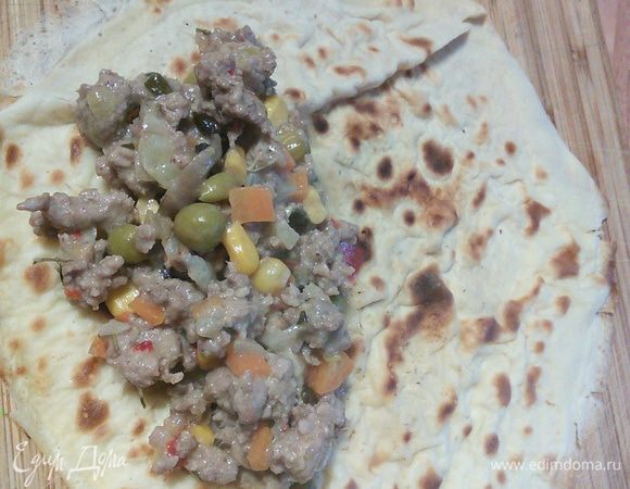 Духовку разогреть до 180°. Форму для запекания смазать маслом. На блин выкладываем фарш, заворачиваем в рулет. 