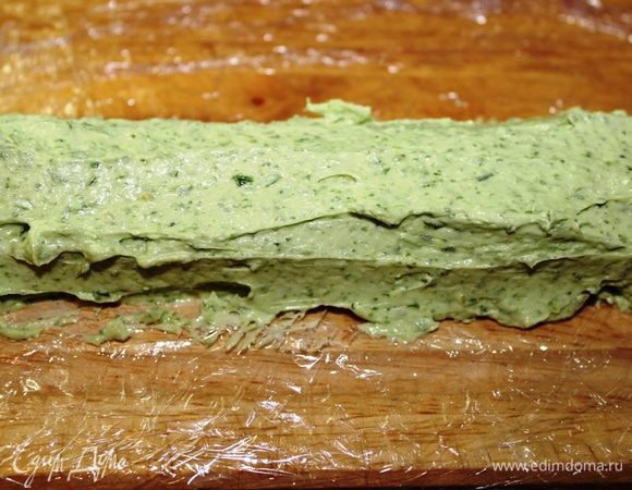 В это время подготовить пищевую пленку...растелить ее в два слоя. Затем вдоль одного края пленки выложить половину охлажденной массы.