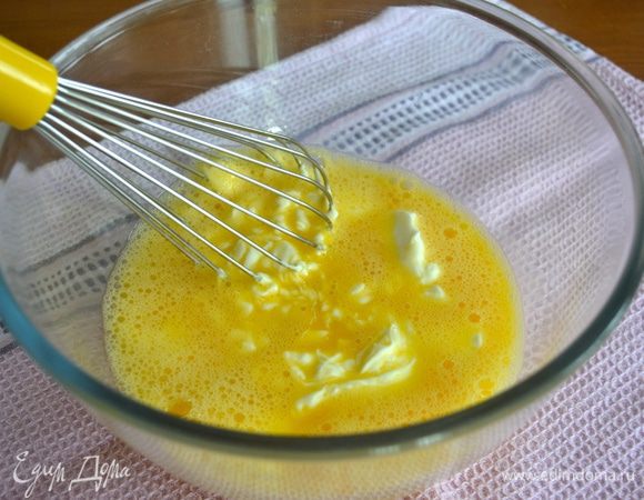 Пирог готовится достаточно быстро... Поэтому включаем разогреваться духовку на 180° C.
В миске взбить венчиком три яйца, посолить. Добавить греческий йогурт и перемешать.