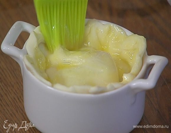 Желток взбить вилкой, смазать сверху тесто и сделать в центре крестообразный надрез.