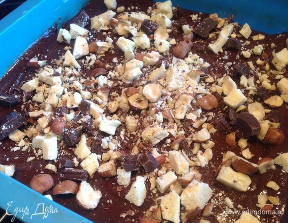 Фундук и оставшийся белый и темный шоколад порубите, и присыпьте им тесто. Выпекайте 25 минут, в предварительно нагретой до 180 градусов духовке. Тесто должно остаться жидковатым в середине. Остудите и нарежьте квадратиками.