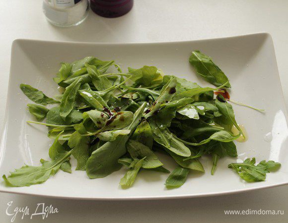На блюдо кладем руколу, сбрызгиваем оливковым маслом и бальзамическим уксусом.