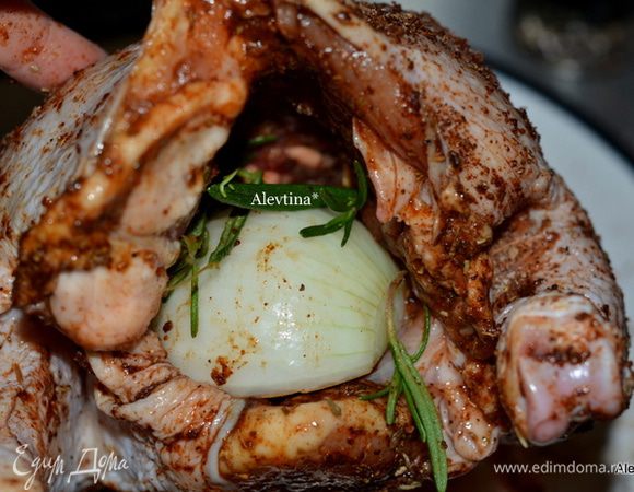 Специями смазать курицу со всех сторон и внутренность. Луковицу порезать на половинки, одну половинку положить внутрь, также веточку розмарина.
