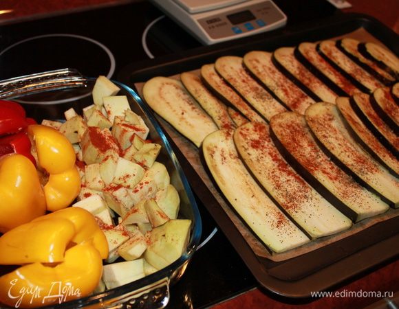 Баклажаны помыть, 2 штуки нарезать тоненько, 1 очистить и нарезать кубиками. Болгарский перец очистить и нарезать на 2 пополам. Выложить на противень слайсы баклажанов и посыпать слегка солью. В жароупорную посуду сложить баклажаны кубиком и перчик. Запекать в духовке около 35 минут. Слайсы баклажанов примерно 20 минут. Перчик всё-таки дольше просится.