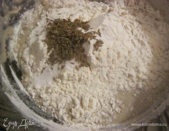 Добавить пшеничную муку, соль и тмин.