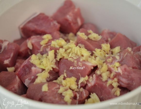 Выложить в глубокую емкость, чеснок порубить мелко, выложить поверх свинины.
