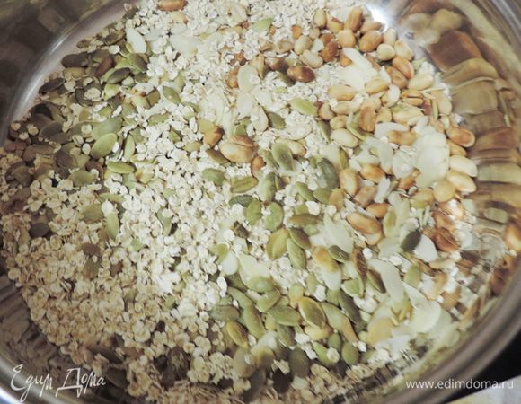Тем временем соединяем овсяные хлопья, семечки и орехи. Прокаливаем их на сковороде с толстым дном до появления легкого приятного запаха. Не пережгите!