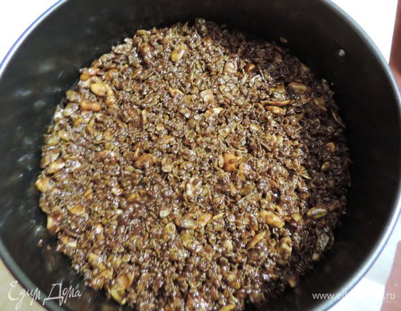 К этому времени у нас уже готова разъемная форма диаметром 20см, дно которой выстелено пергаментом. Выкладываем туда шоколадную смесь, разравниваем, утрамбовываем и отправляем в холодильник.